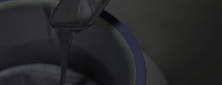 Close-up of purple wax getting melted in a warmer on a gray stylized background 