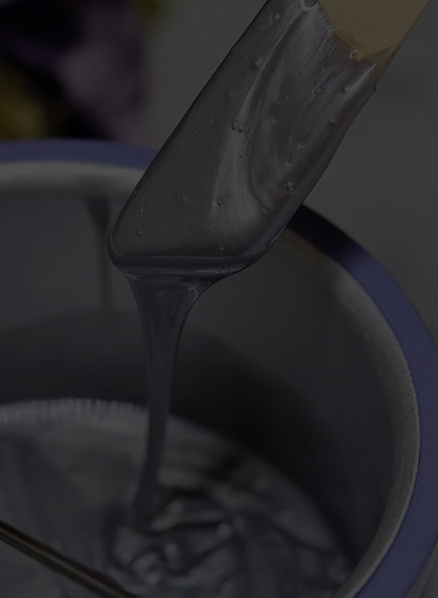 Close-up of purple wax getting melted in a warmer on a gray stylized background 