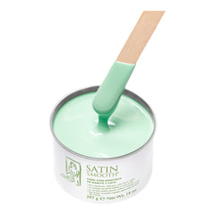 Green satin smooth product with a spatula on a white background