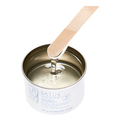 Satin smooth wax on a wooden applicator on a white background