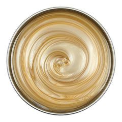 Close-up of a bowl with a swirling pattern of gold and white cream.