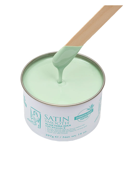 Dripping wax stick dipped into an open can of Satin Smooth Aloe Vera Wax showing its full light green color & texture